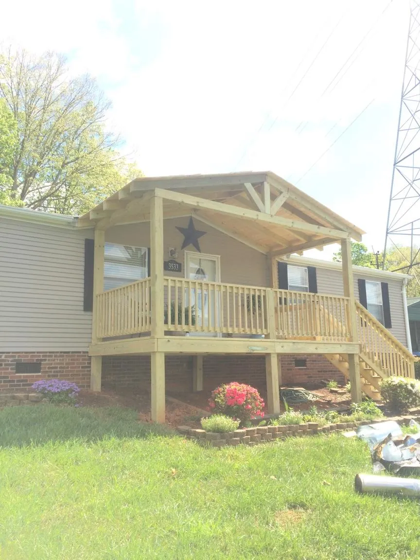 New gabled porch roof and deck railing added to a ranch home in Adamsville